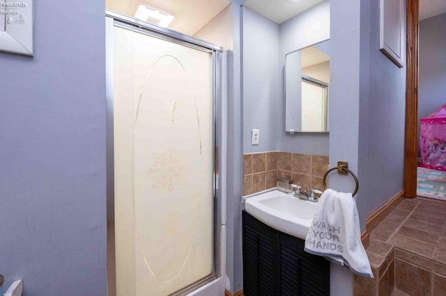 bathroom with vanity and a shower with door