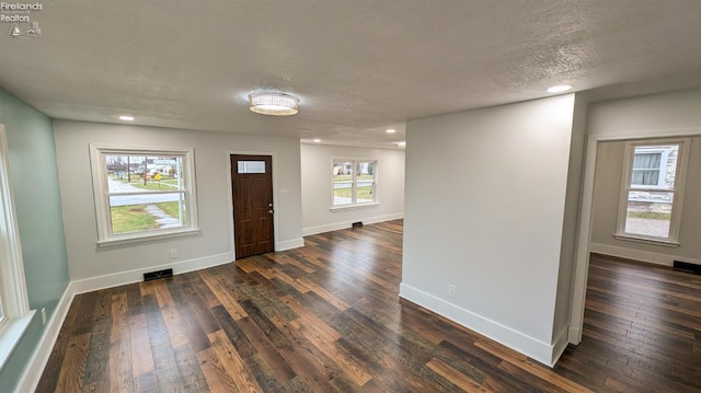 entrance foyer with dark hardwood / wood-style floors and a textured ceiling