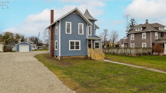 view of front of house with a front yard, an outbuilding, and a garage