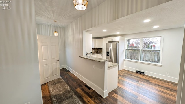 kitchen with light stone countertops, white cabinetry, dark hardwood / wood-style flooring, and stainless steel fridge with ice dispenser