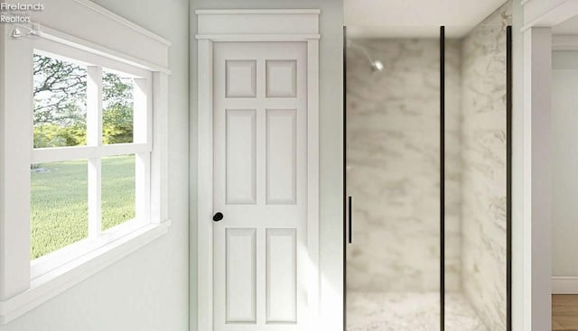 bathroom featuring a shower with shower door