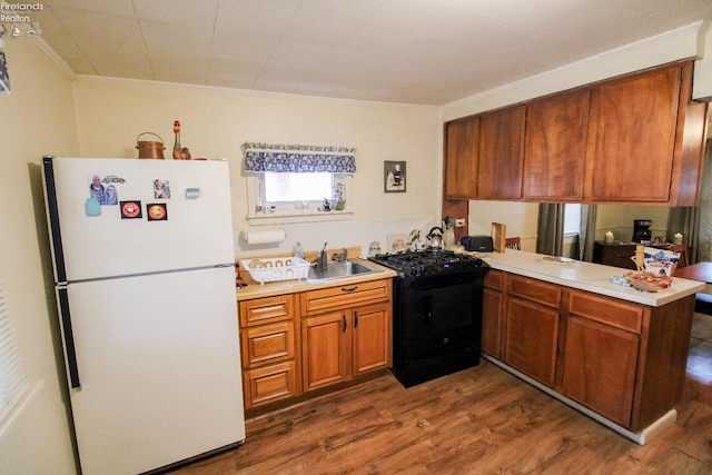 kitchen with black range with electric stovetop, kitchen peninsula, white fridge, and dark hardwood / wood-style floors