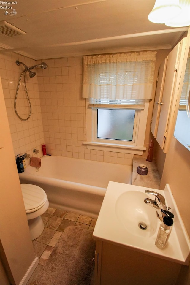 full bathroom with vanity, tile patterned flooring, tiled shower / bath, and toilet