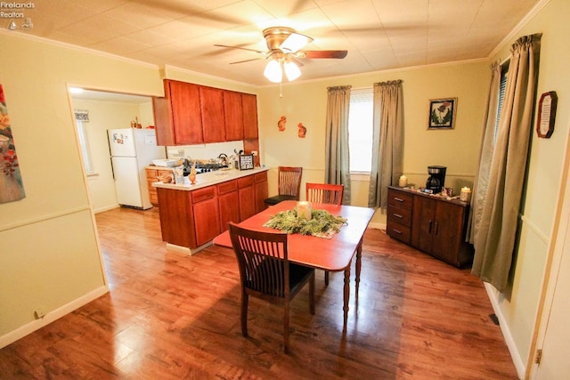 kitchen with ceiling fan, white refrigerator, wood-type flooring, and crown molding