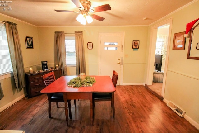 dining room with dark hardwood / wood-style floors, ceiling fan, and crown molding