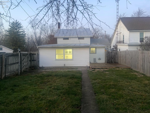 back of house with a lawn and a wooden deck