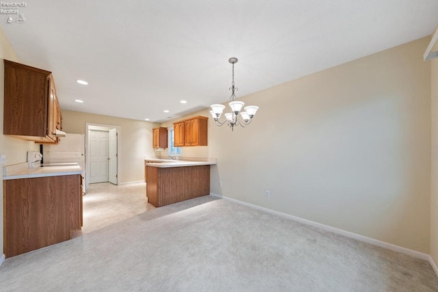 kitchen featuring a chandelier, kitchen peninsula, light carpet, and hanging light fixtures