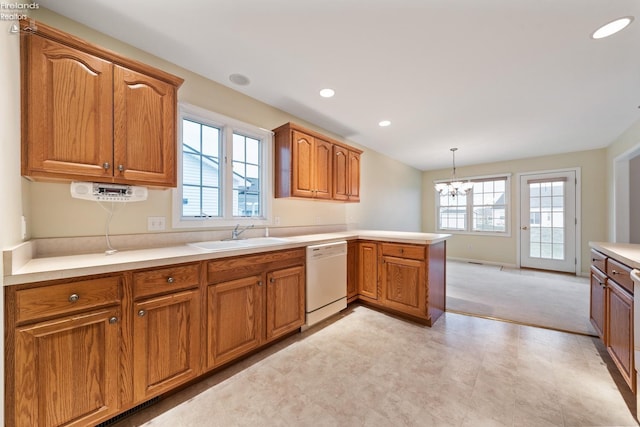 kitchen featuring white dishwasher, plenty of natural light, sink, and a notable chandelier