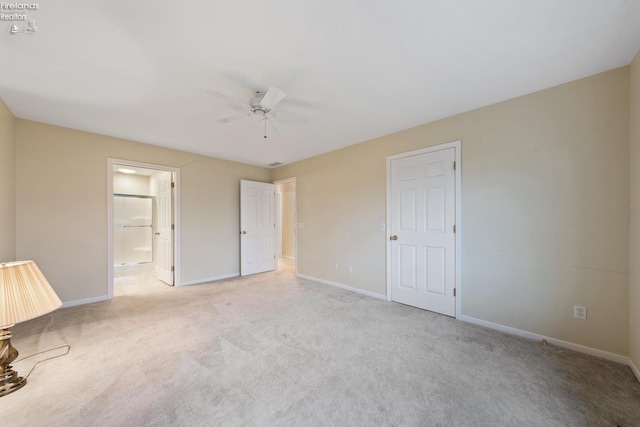 unfurnished bedroom with ensuite bath, ceiling fan, and light colored carpet