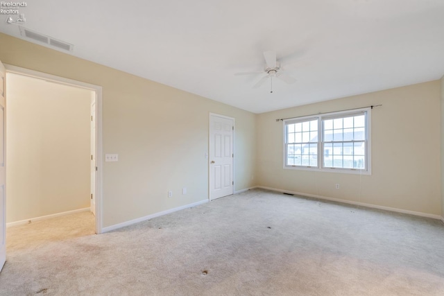 spare room featuring light carpet and ceiling fan