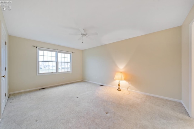 carpeted spare room with ceiling fan