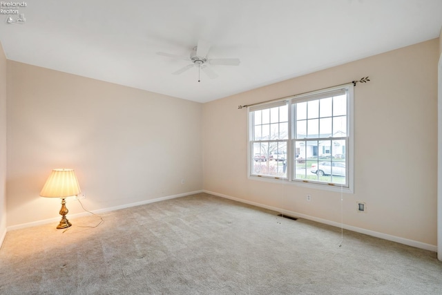 carpeted spare room featuring ceiling fan