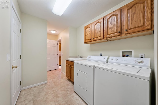 laundry room featuring cabinets, washing machine and dryer, and sink