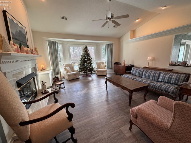 living room with ceiling fan, dark hardwood / wood-style floors, and vaulted ceiling