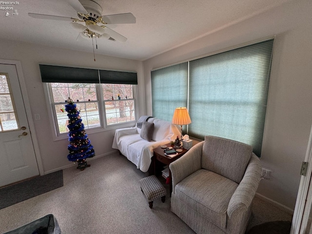 living area with plenty of natural light, ceiling fan, carpet floors, and a textured ceiling