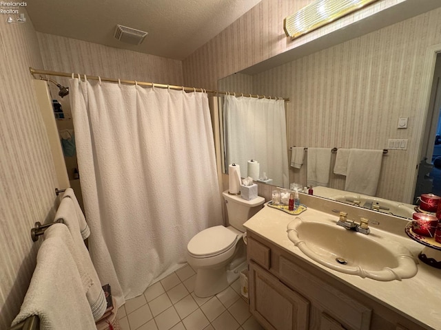 bathroom featuring toilet, vanity, a textured ceiling, and tile patterned floors