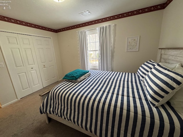 carpeted bedroom featuring a closet and a textured ceiling