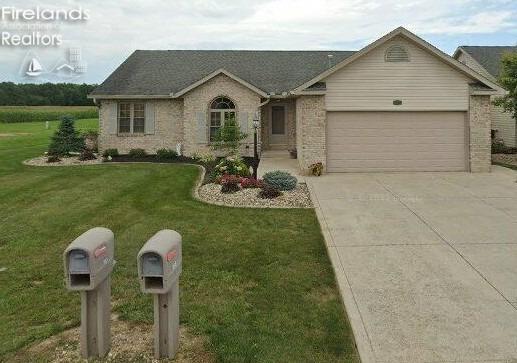 ranch-style home with a garage and a front yard