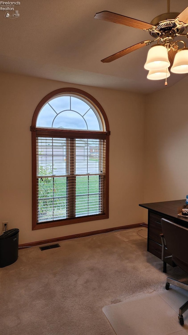 unfurnished office featuring ceiling fan and light colored carpet