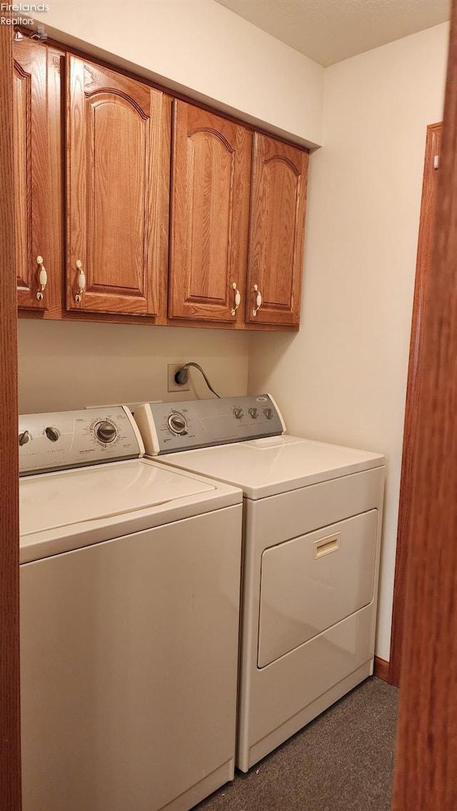 washroom featuring washing machine and dryer and cabinets