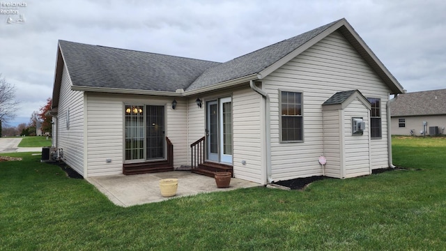 rear view of house featuring a patio area, a yard, and central air condition unit