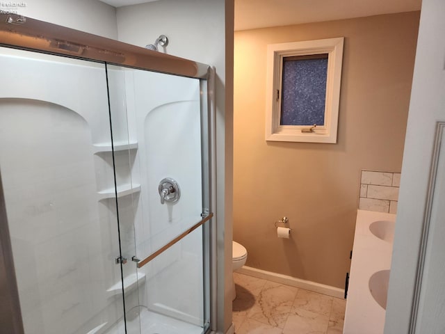 bathroom featuring vanity, toilet, and a shower with door