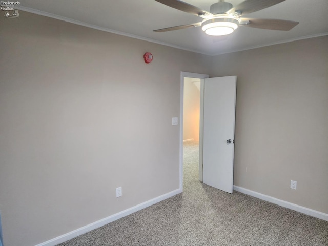 carpeted empty room featuring ceiling fan and crown molding