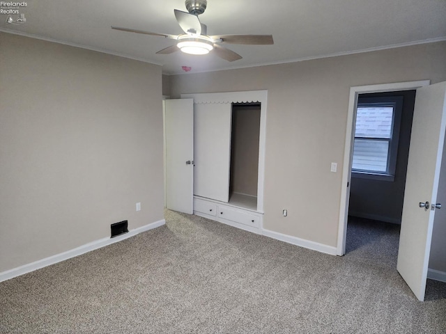 unfurnished bedroom featuring carpet flooring, ceiling fan, and ornamental molding