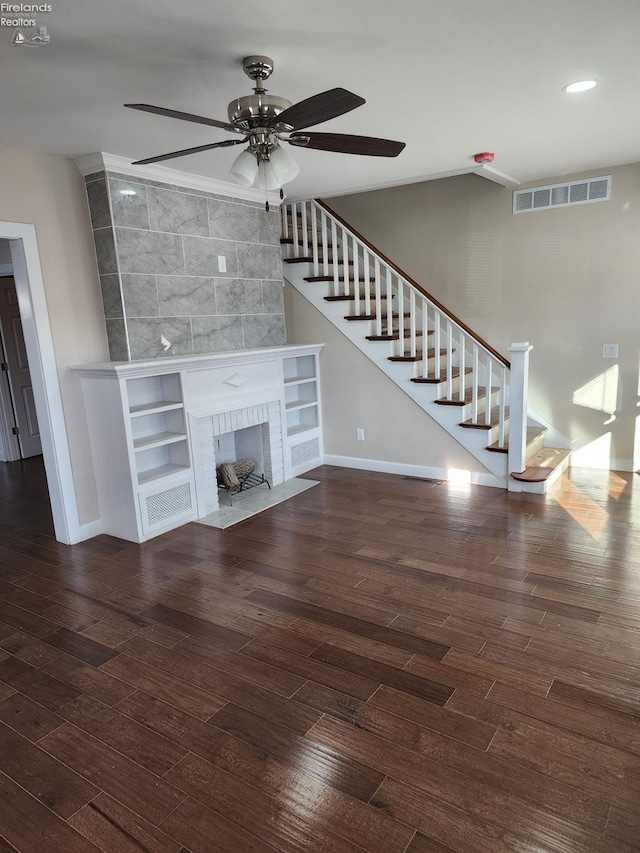 unfurnished living room with a fireplace, ceiling fan, and dark wood-type flooring