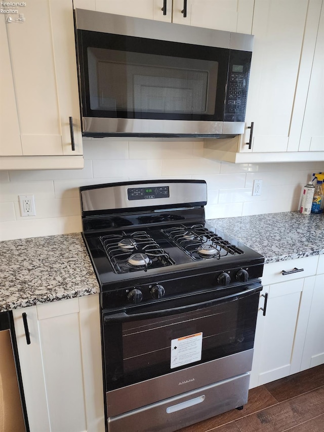 kitchen featuring white cabinetry, light stone countertops, and appliances with stainless steel finishes