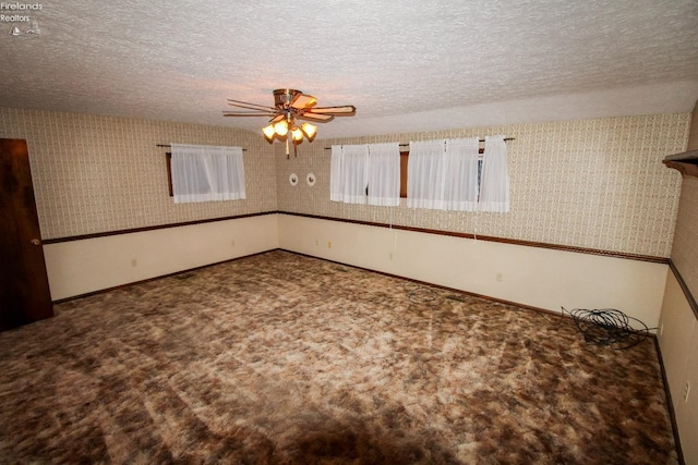 unfurnished room with ceiling fan, carpet, and a textured ceiling