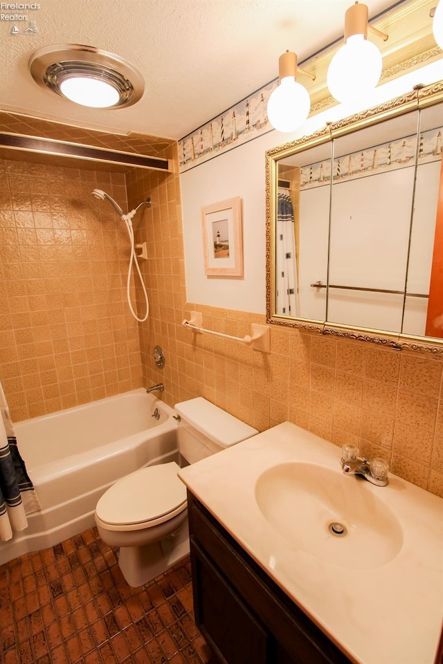 full bathroom featuring tile patterned floors, shower / bath combination with curtain, toilet, vanity, and tile walls