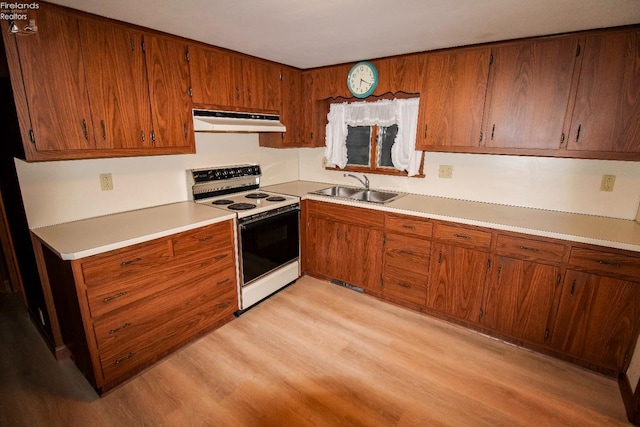 kitchen featuring white electric range oven, sink, and light hardwood / wood-style flooring