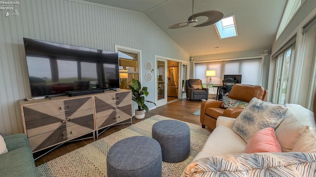 living room featuring lofted ceiling with skylight, french doors, ceiling fan, and hardwood / wood-style flooring