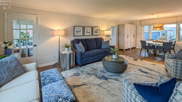 living room featuring dark wood-type flooring and ornamental molding