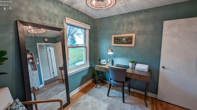 office space with a chandelier and light wood-type flooring