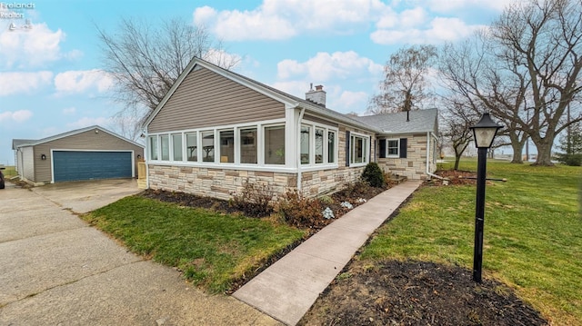 view of front of property with a garage, an outbuilding, and a front lawn