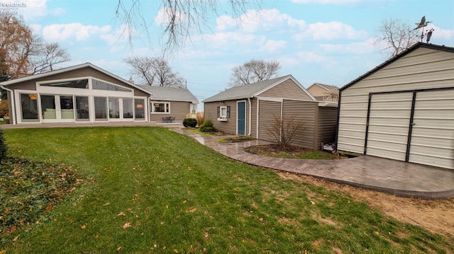 rear view of house with a yard, an outbuilding, and a garage