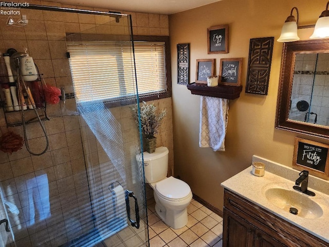 bathroom with tile patterned floors, an enclosed shower, toilet, vanity, and tile walls