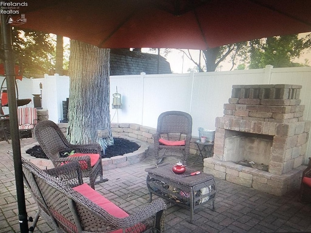 view of patio featuring an outdoor stone fireplace