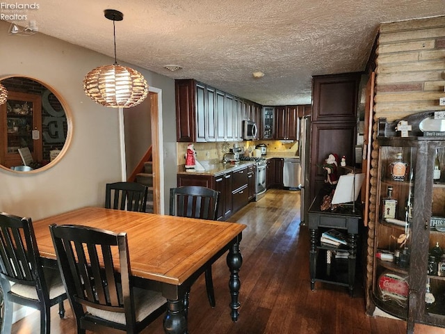 dining space with dark hardwood / wood-style floors, a textured ceiling, wooden walls, and a chandelier