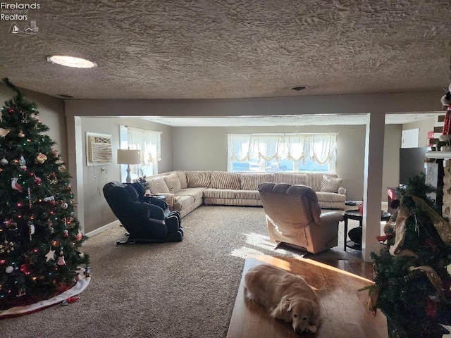 living room featuring carpet flooring, a wall mounted AC, and a textured ceiling