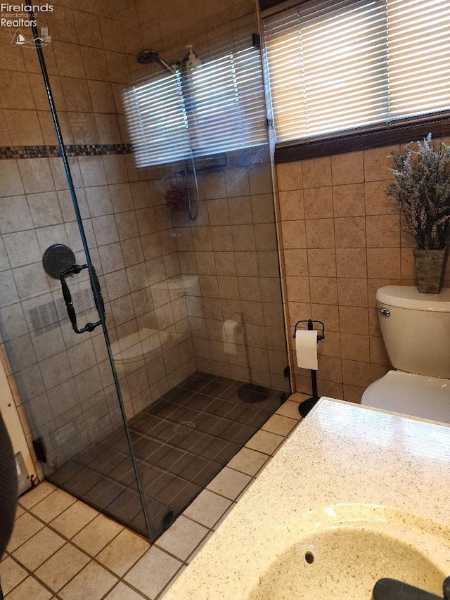 bathroom featuring a shower with door and toilet