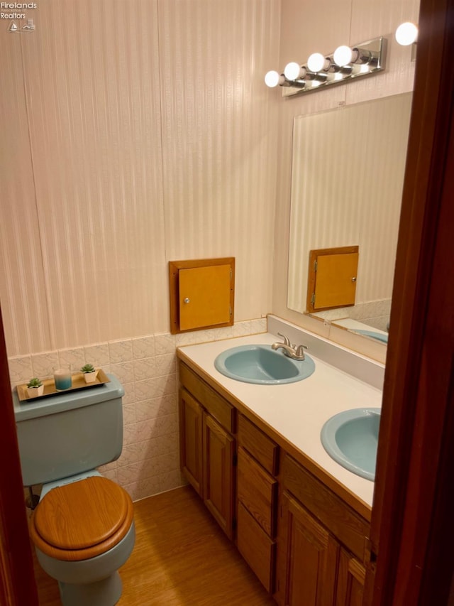 bathroom featuring hardwood / wood-style floors, vanity, tile walls, and toilet