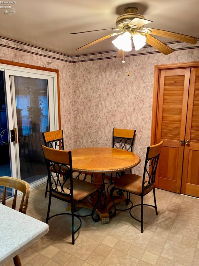 dining space with ceiling fan and crown molding