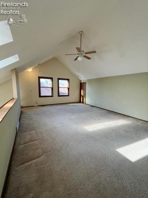 bonus room featuring carpet flooring, ceiling fan, and vaulted ceiling with skylight