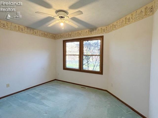 unfurnished room featuring carpet, ceiling fan, and a textured ceiling