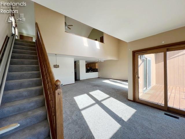 unfurnished living room featuring carpet flooring and ceiling fan