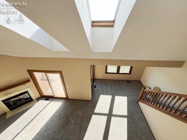 living room with a skylight and dark carpet