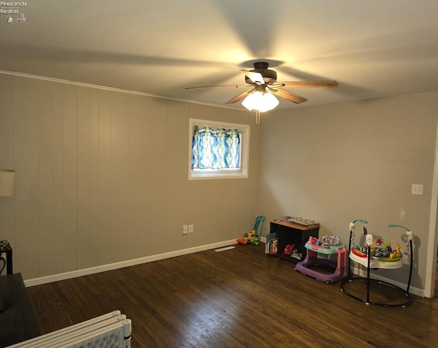 recreation room with dark hardwood / wood-style flooring, ceiling fan, and crown molding